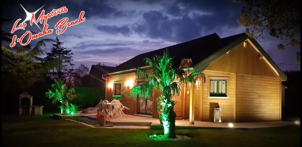 a house with a palm tree in the yard at night at Les Mystères D'Omaha Beach in Surrain