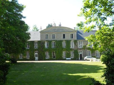 une grande maison avec une grande pelouse devant elle dans l'établissement Manoir Saint Hubert, à Saint-Vigor-le-Grand