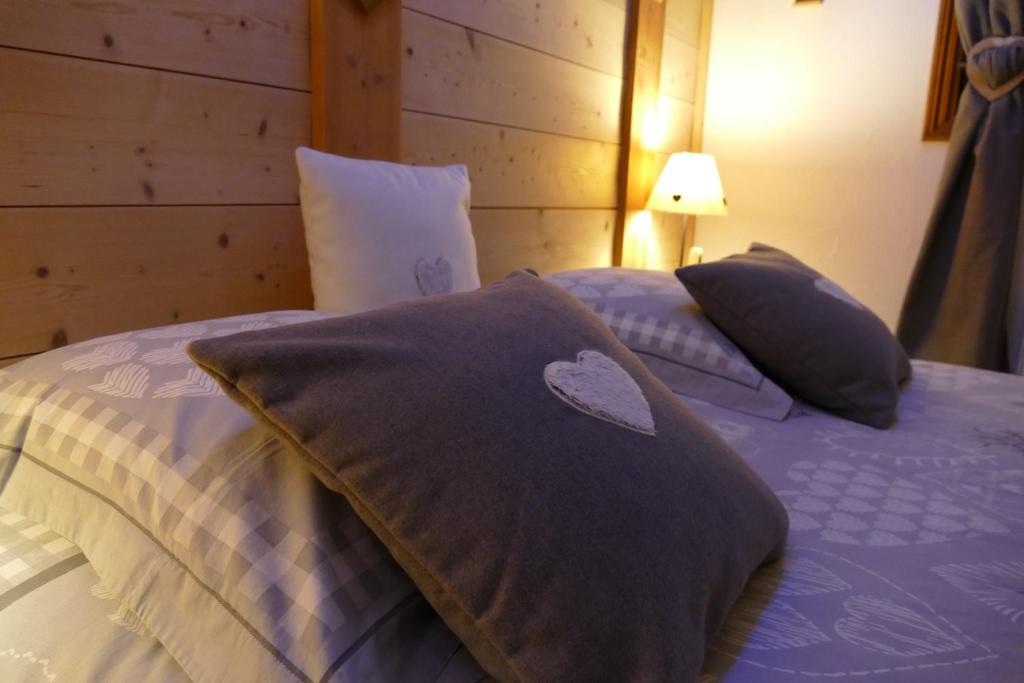 - un lit avec des draps et des oreillers violets dans une chambre dans l'établissement Chalet coup de coeur, à Passy