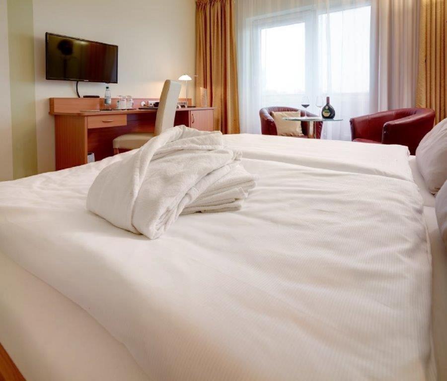 Postel nebo postele na pokoji v ubytování Kurhotel Pyramide Bad Windsheim