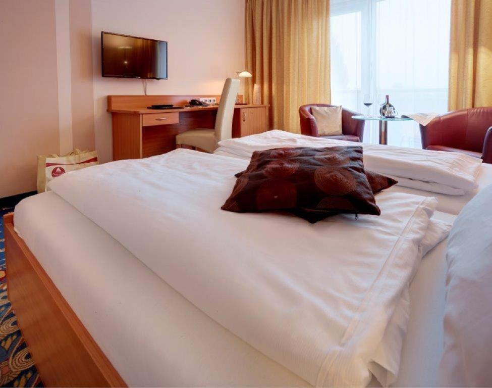 Postel nebo postele na pokoji v ubytování Kurhotel Pyramide Bad Windsheim