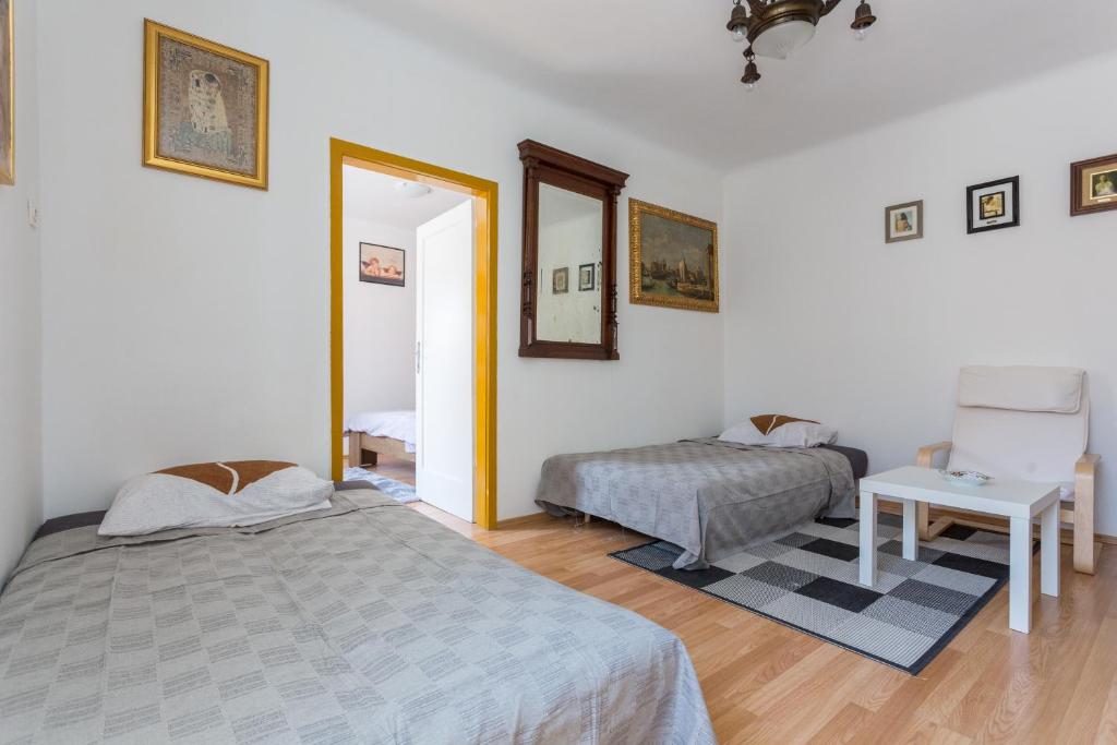 a bedroom with two beds and a table and a mirror at Sogaro in Dubrovnik