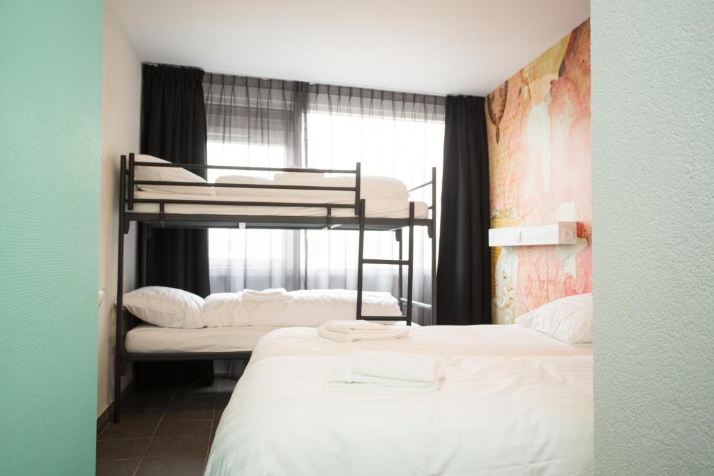 een kamer met twee stapelbedden en een raam bij Beach Hotel Katwijk in Katwijk