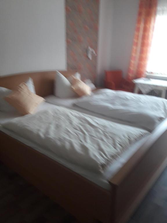2 Betten mit weißer Bettwäsche und Kissen im Schlafzimmer in der Unterkunft Haus Helene in Einruhr