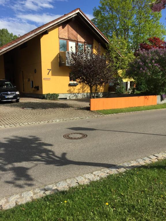 a yellow house on the side of a street at Zimmer in Lautrach in Lautrach