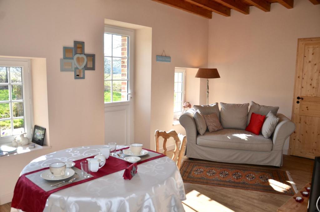 a living room with a table and a couch at Domaine de la Ronville in Wimereux