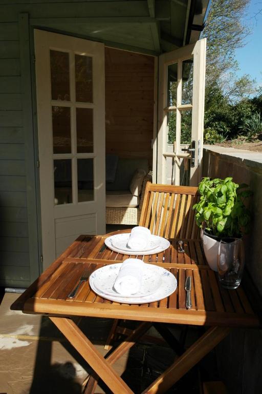 a wooden table with plates on it on a porch at Ashford house 'The Snug' private hot tub in Fylingthorpe