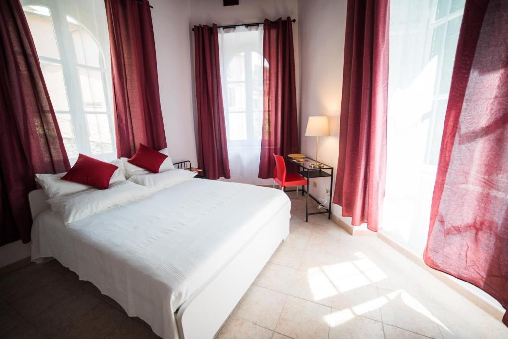 a bedroom with a large white bed with red curtains at Modern Apartments in Palestrina