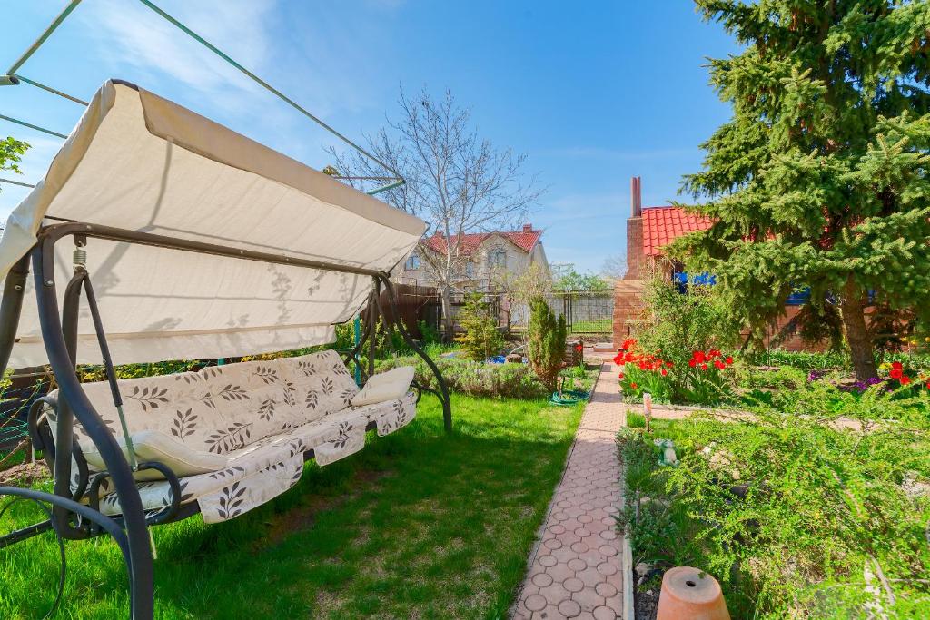 a garden with a couch in the grass at Мини Отель Милый in Sanzhiyka