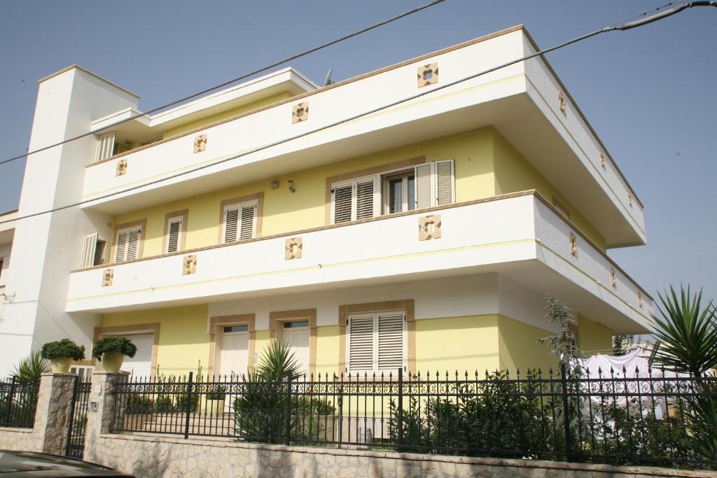 a yellow and white building with a fence at Casa Zara in Presicce