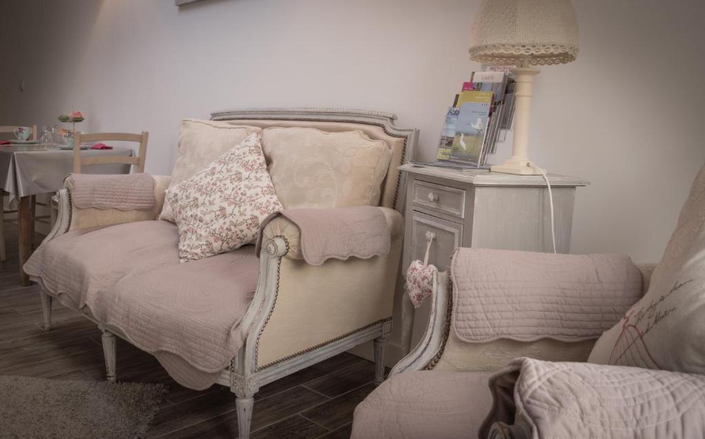 アブヴィルにあるLes Trois Rosesのベッド1台、椅子、テーブルが備わる客室です。