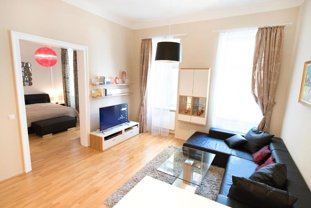 a living room with a couch and a tv at Anna Maria Apartments in Vienna Citycenter in Vienna