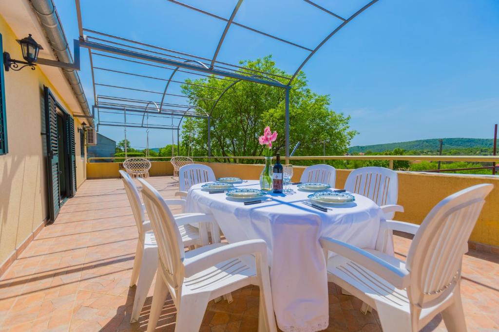 una mesa blanca con sillas blancas en el patio en Kuća za odmor Rajčić, en Unešić