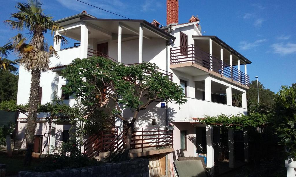 een wit huis met een palmboom ervoor bij Apartment Marija in Umag