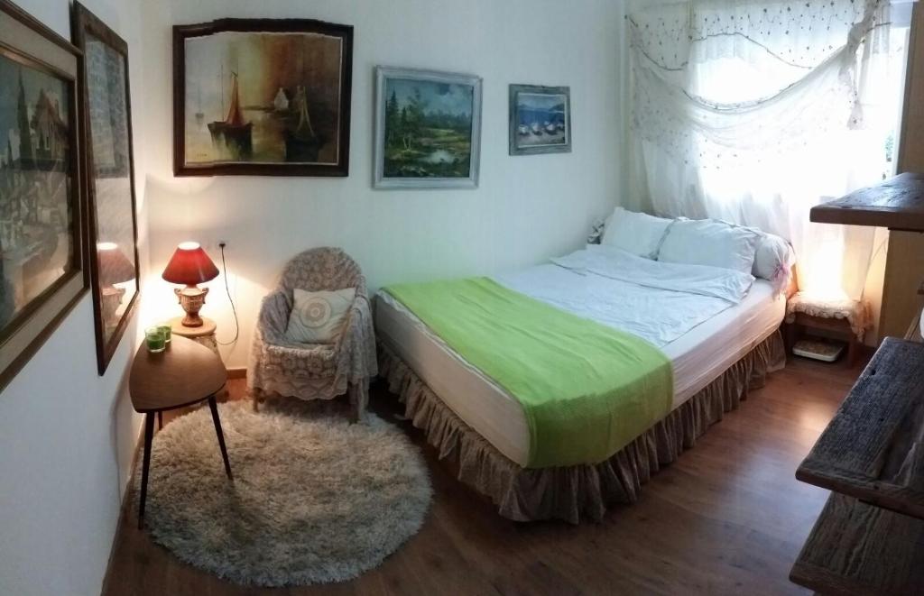 a small bedroom with a bed and a chair at Goldy Suite in Haifa