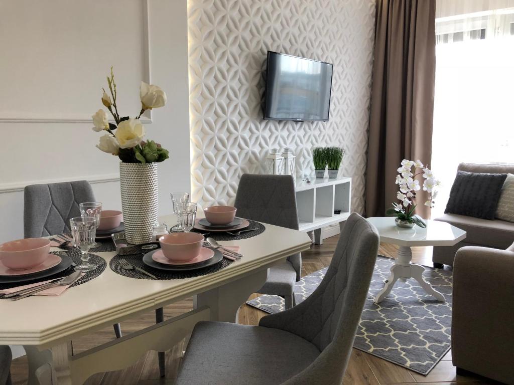 キェルツェにあるFamily & Business Elegant Apartments ul Warszawska - 2 Bedroom, Balcony, Parkingのダイニングルーム(テーブル、椅子、テレビ付)