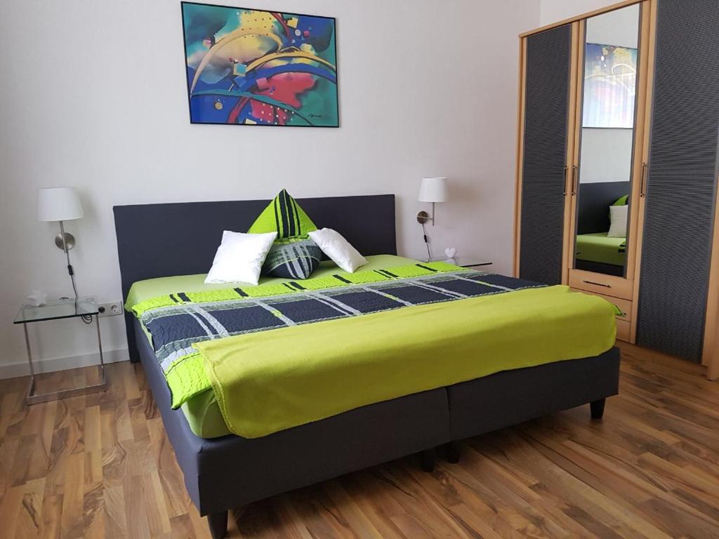 ein Schlafzimmer mit einem großen Bett und einer gelben Decke in der Unterkunft Lorenz Apartment in Hattingen