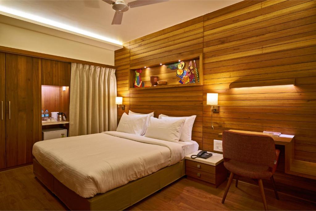a bedroom with a bed and a desk and a chair at Hotel Atharv Top Rated Business Hotel in Kolhapur in Kolhapur