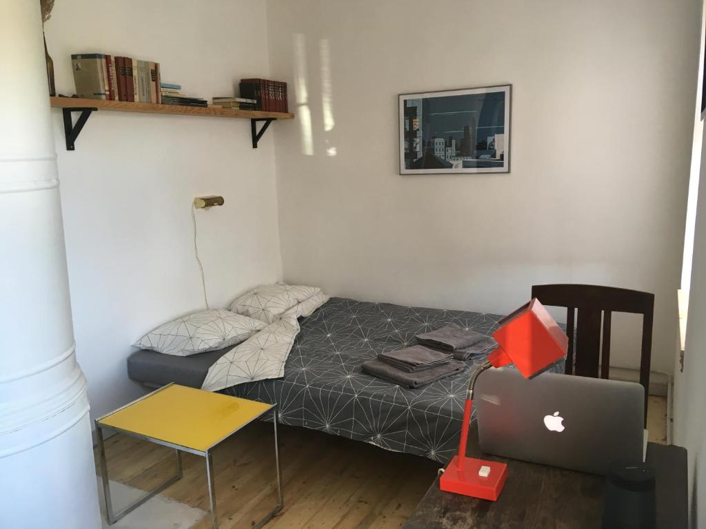 a small bedroom with a bed and a desk and a laptop at Vintage Design Apartment in Kuldīga