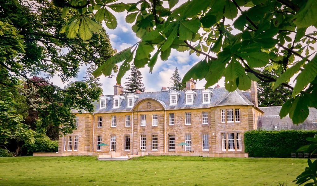 a large brick building in a field of grass at Blervie House in Forres