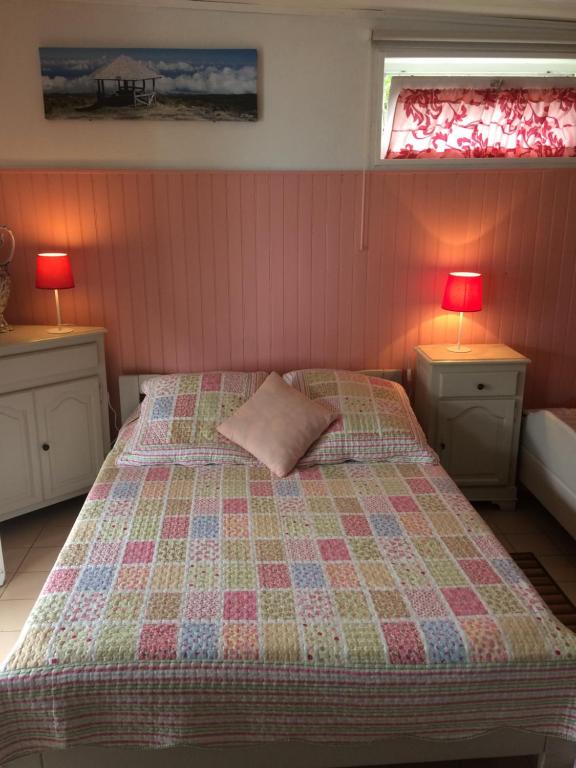 1 dormitorio con 1 cama con 2 mesas y 2 lámparas en chez mamie, en Les Avirons
