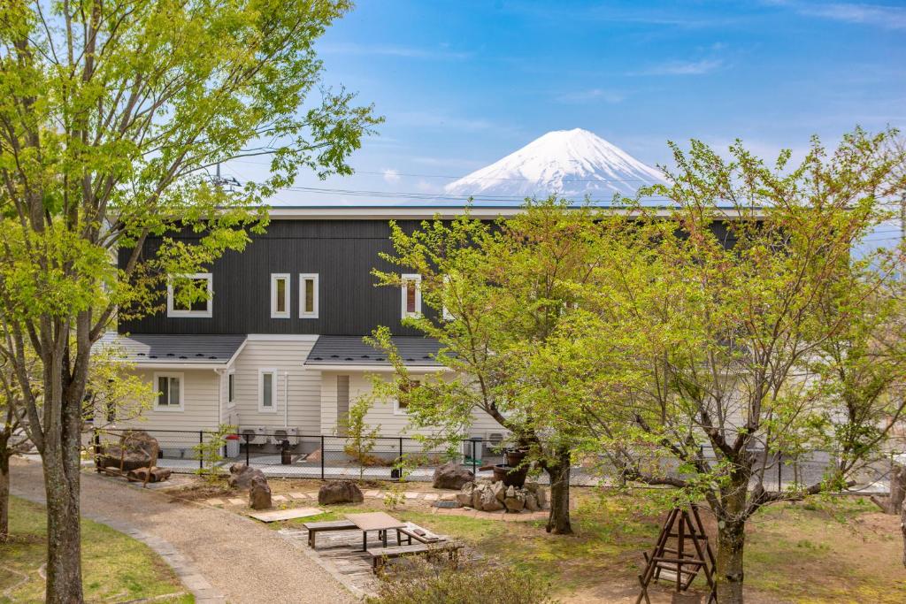 un edificio con una montaña cubierta de nieve en el fondo en Villa Yushin en Fujikawaguchiko