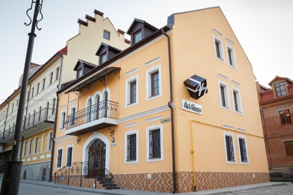 ein gelbes Gebäude an der Straßenseite in der Unterkunft Art house Hostel in Kamjanez-Podilskyj