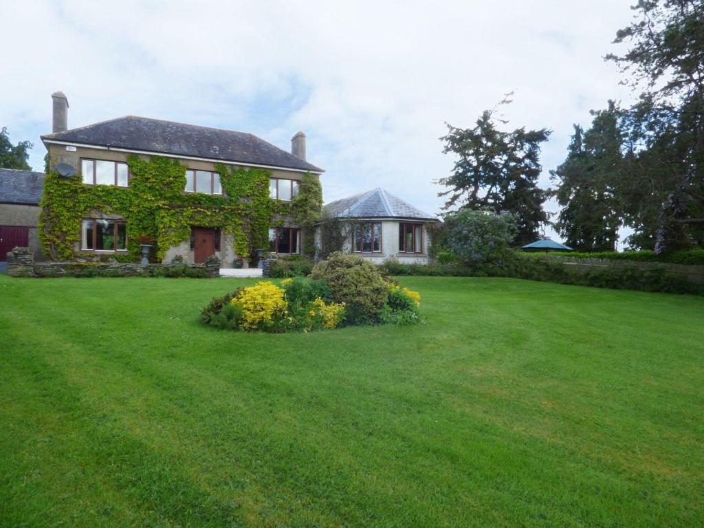 uma casa com um grande quintal com relva verde em Maifield em Mullennaglogh