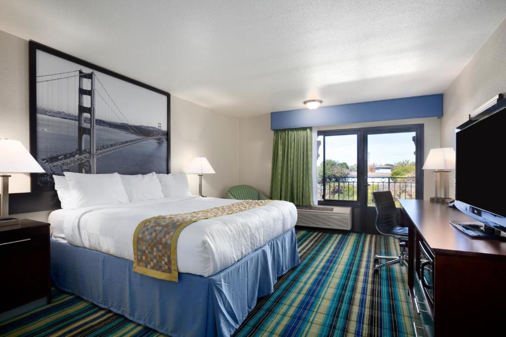 a hotel room with a bed and a desk and a window at Super 8 by Wyndham Vallejo/Napa Valley in Vallejo