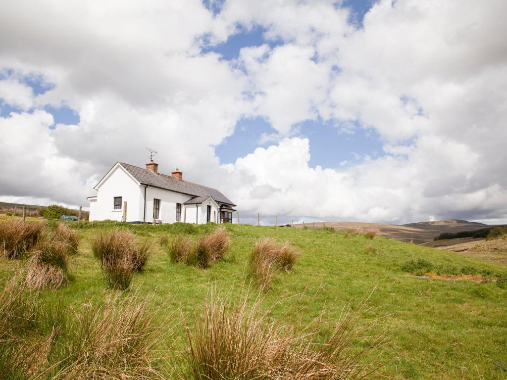 una casa blanca en una colina en un campo en Shepherds' Retreat, en Greencastle