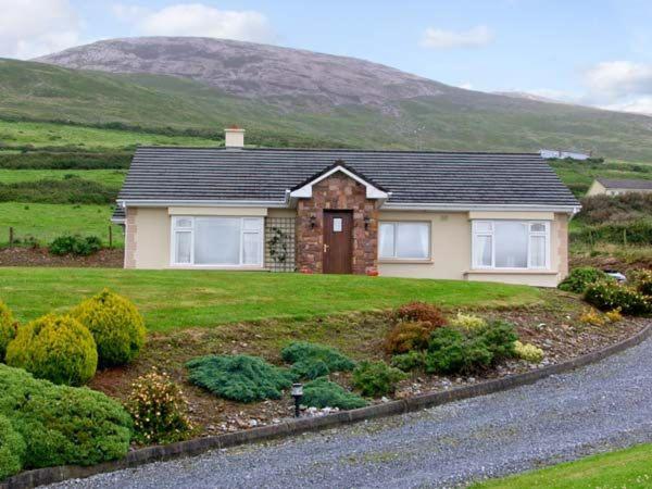 a house in a field with a mountain in the background at Heron's Nest in Inch
