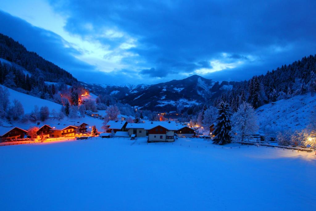 un pueblo en la nieve por la noche en Landhaus Marlies Apartments, en Zell am See