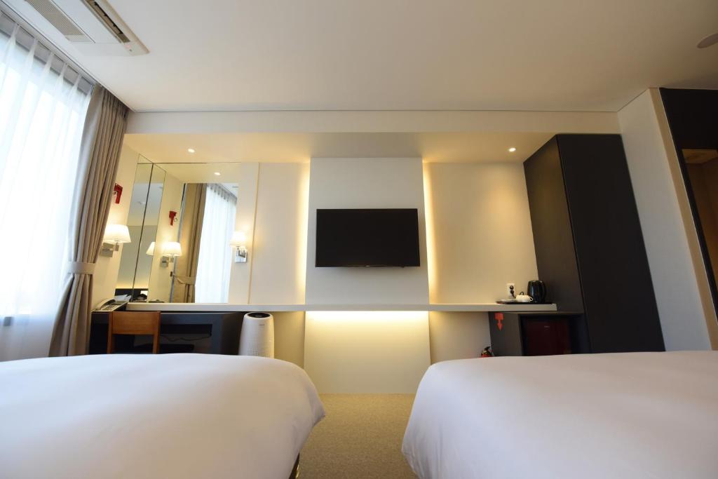 Postel nebo postele na pokoji v ubytování Geoje Artnouveau Suite Hotel