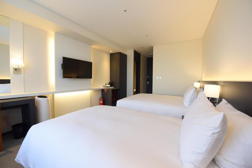 Postel nebo postele na pokoji v ubytování Geoje Artnouveau Suite Hotel