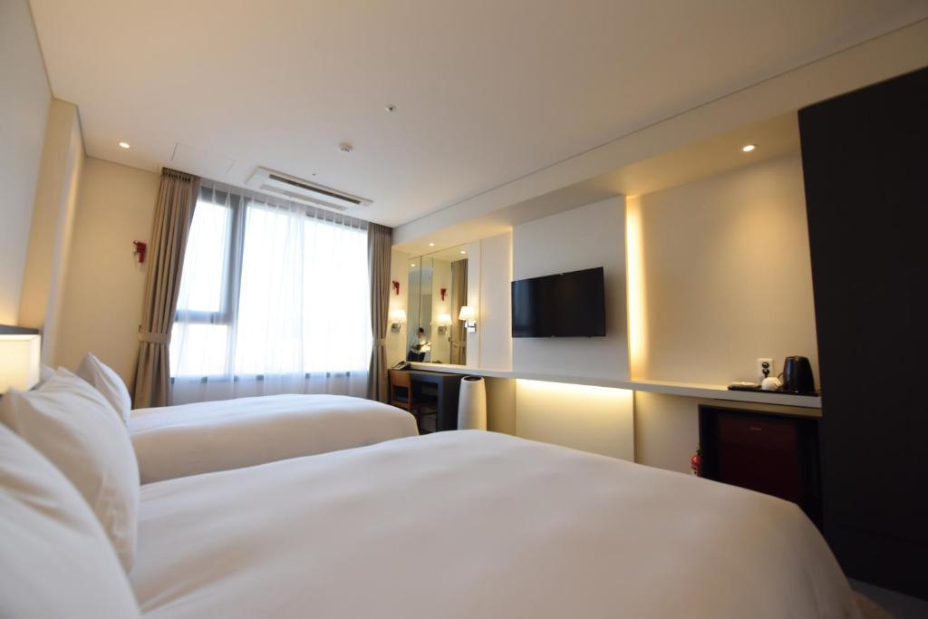 Postel nebo postele na pokoji v ubytování Geoje Artnouveau Suite Hotel