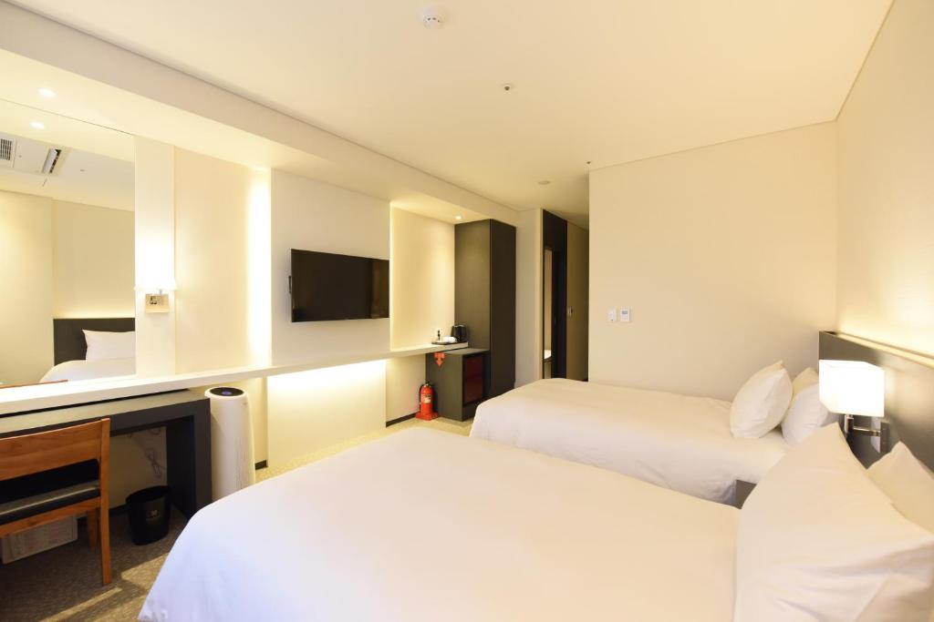Postel nebo postele na pokoji v ubytování Geoje Artnouveau Suite Hotel