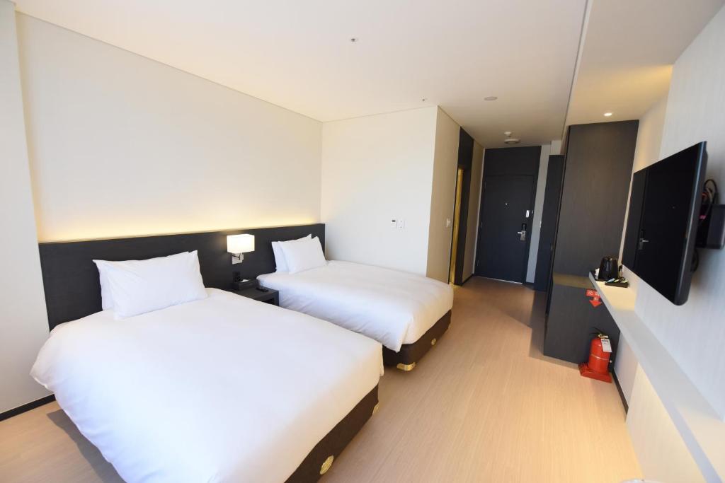 Postel nebo postele na pokoji v ubytování Geoje Artnouveau Suite Hotel