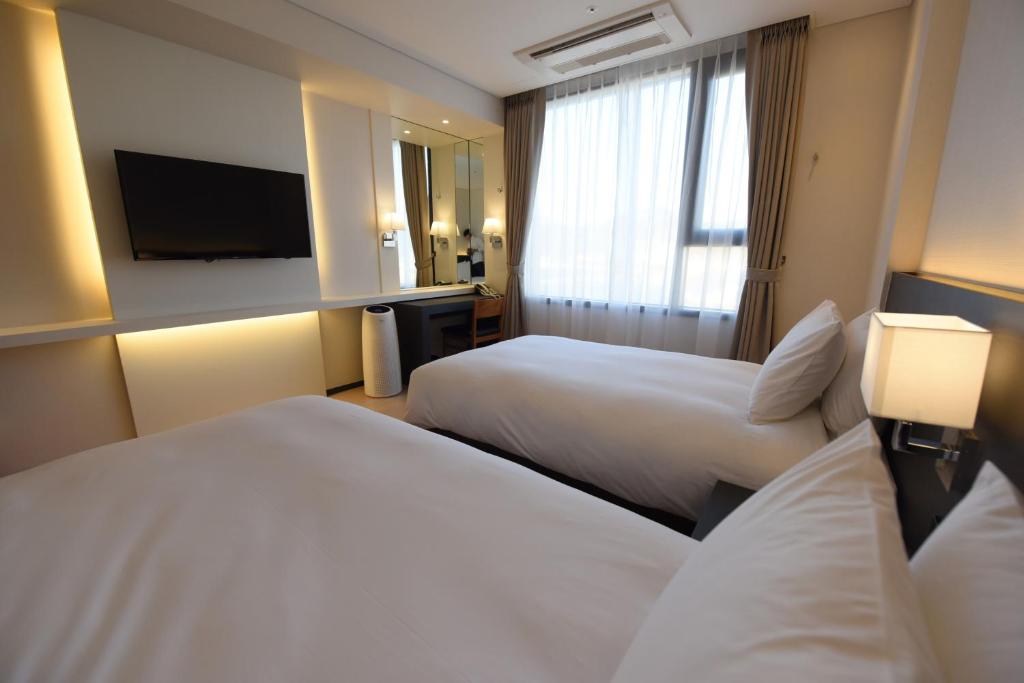 Postel nebo postele na pokoji v ubytování Geoje Artnouveau Suite Hotel