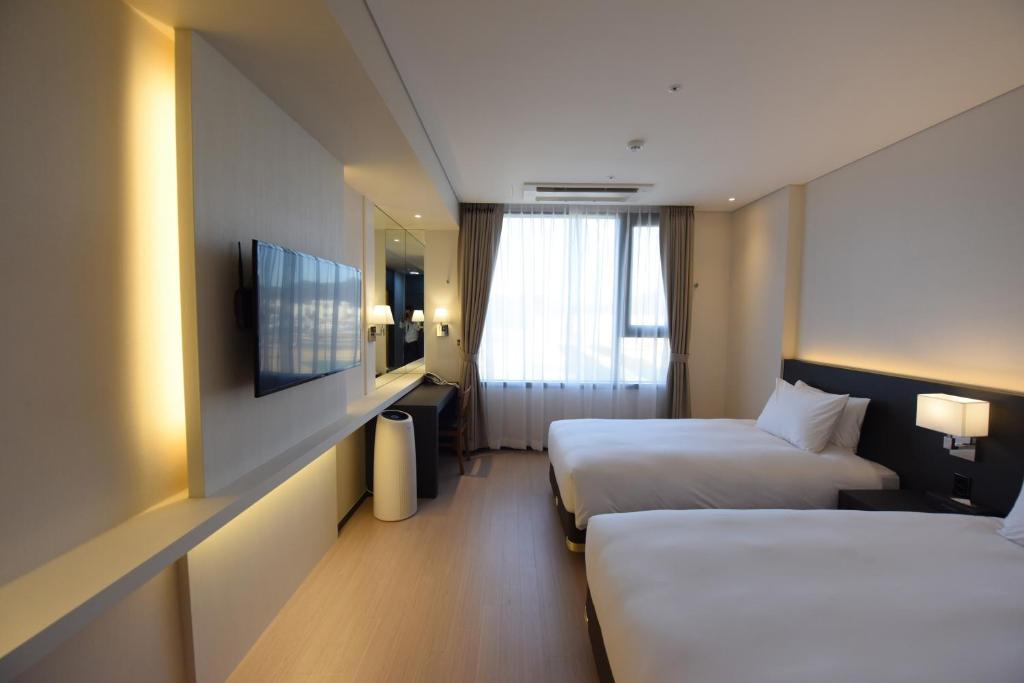 Postel nebo postele na pokoji v ubytování Geoje Artnouveau Suite Hotel