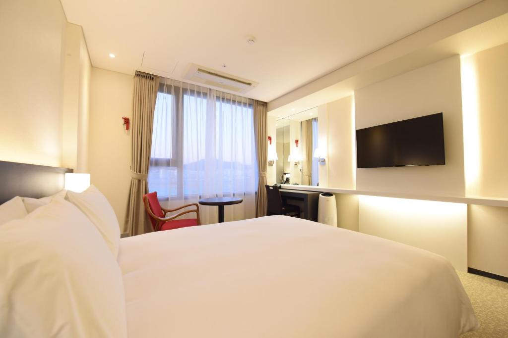 Postel nebo postele na pokoji v ubytování Geoje Artnouveau Suite Hotel
