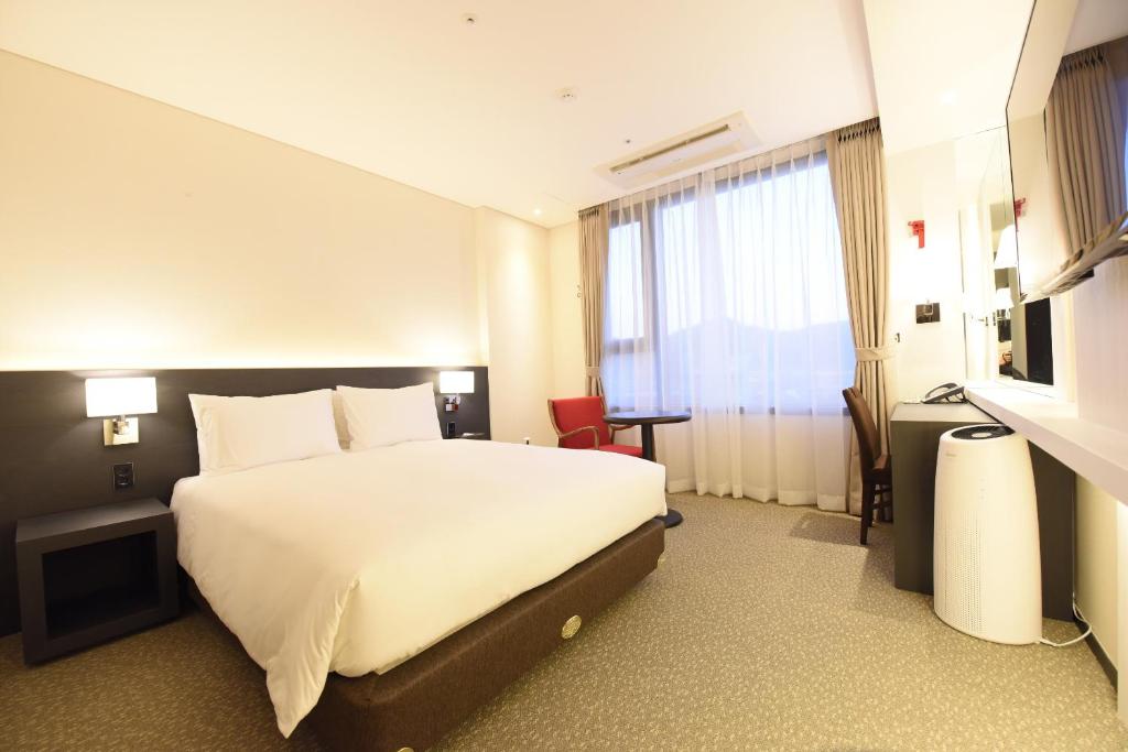 Postel nebo postele na pokoji v ubytování Geoje Artnouveau Suite Hotel