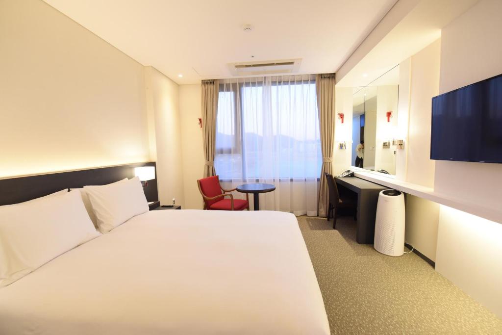 Postel nebo postele na pokoji v ubytování Geoje Artnouveau Suite Hotel