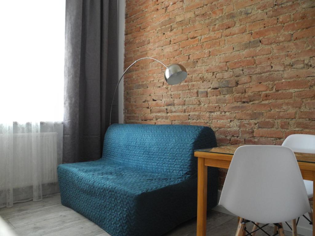 una silla azul sentada junto a una pared de ladrillo en Apartament N°10 en Lodz