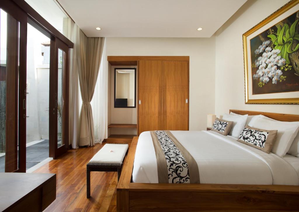 a bedroom with a large bed in a room at Daluman Villas in Seminyak