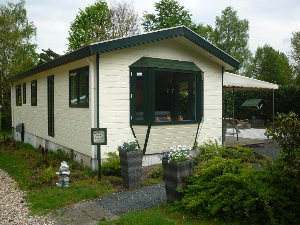 een kleine witte hut met een groen dak bij Chalet Wester Park Lierderholt in Beekbergen
