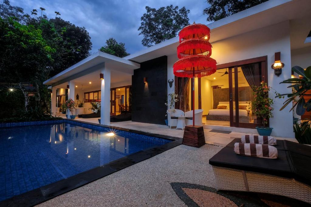 a villa with a swimming pool and a bedroom at Villa Collard in Senggigi