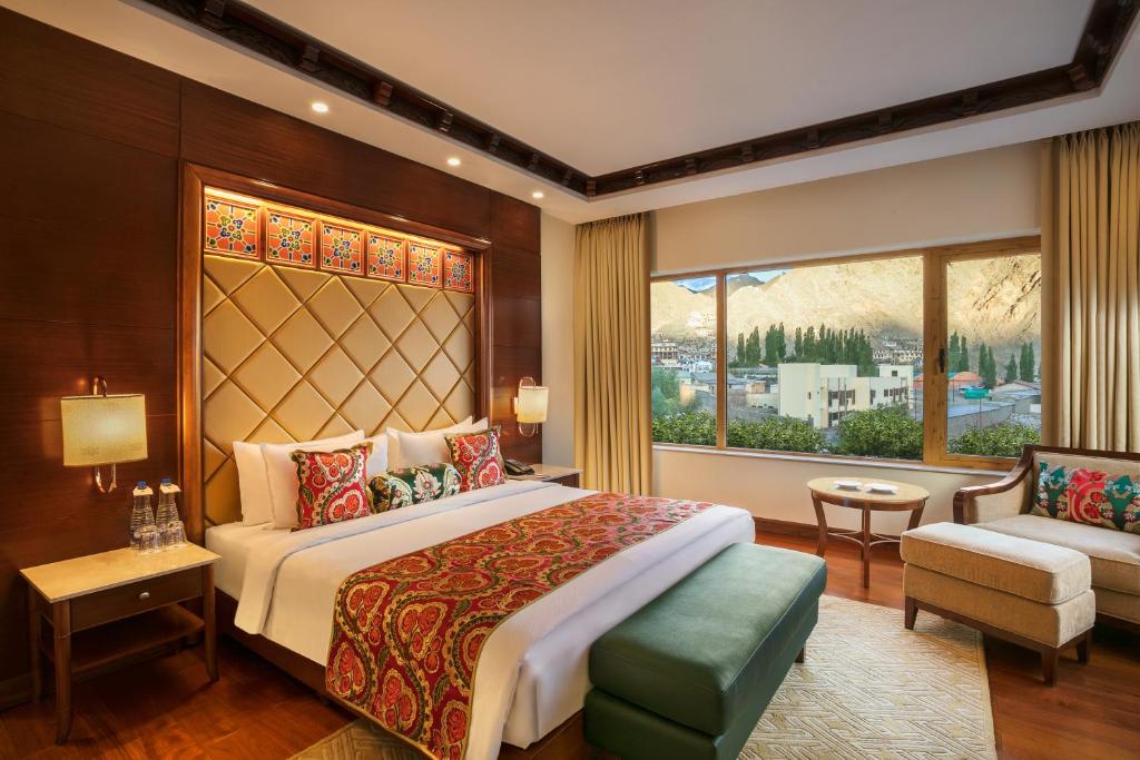 a bedroom with a large bed and a window at The Grand Dragon Ladakh in Leh