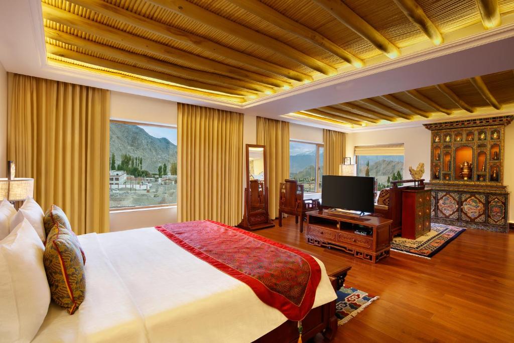 a bedroom with a bed and a flat screen tv at The Grand Dragon Ladakh in Leh