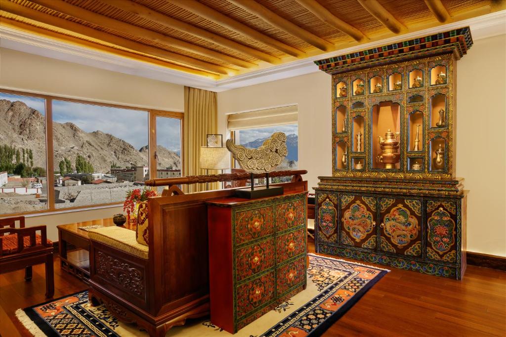 a bedroom with a large bed and a desk at The Grand Dragon Ladakh in Leh