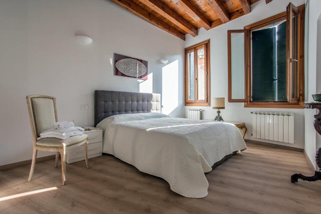 una camera con un grande letto e una sedia di Venice Love Suite a Venezia